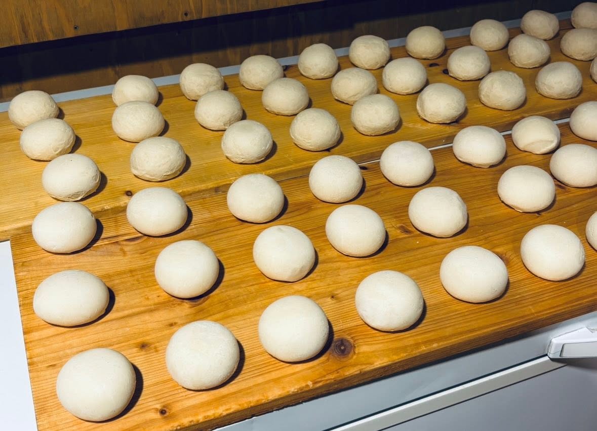 Vorbereitete Dampfnudel-Teiglinge beim traditionellen Backhandwerk